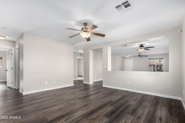 unfurnished living room with visible vents, a ceiling fan, dark wood-style flooring, and baseboards
