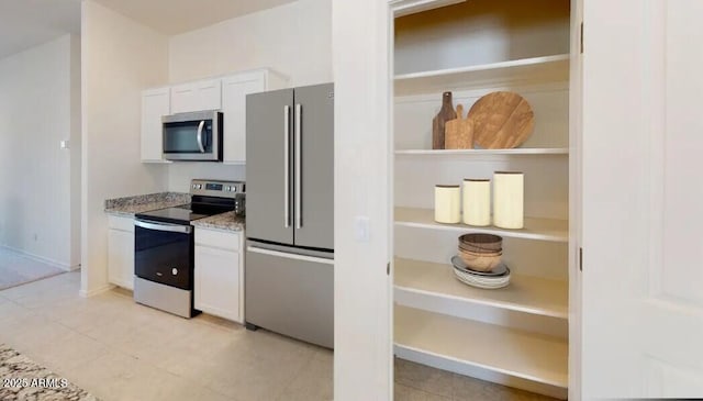 5782 E Orion Rd, Florence, AZ 85132 - kitchen with appliances with stainless steel finishes, white cabinets, light tile patterned floors, light stone countertops, and baseboards