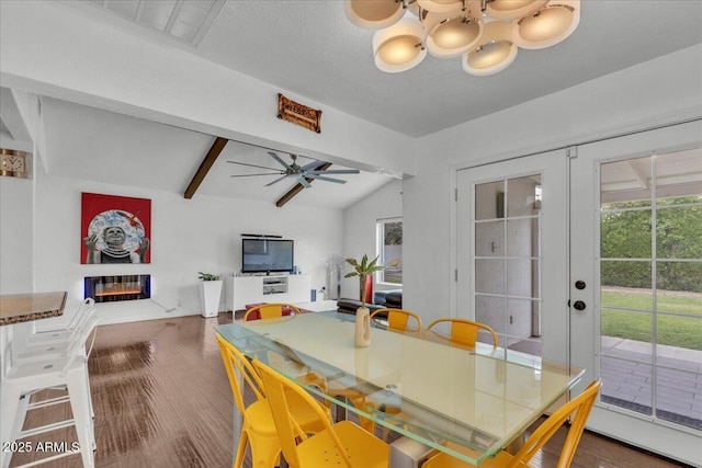6747 N 12th St, Phoenix, AZ 85014 - dining area featuring wood finished floors, ceiling fan with notable chandelier, vaulted ceiling with beams, a glass covered fireplace, and french doors
