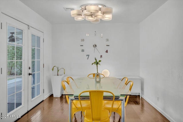 6747 N 12th St, Phoenix, AZ 85014 - dining space with french doors, wood finished floors, baseboards, visible vents, and an inviting chandelier