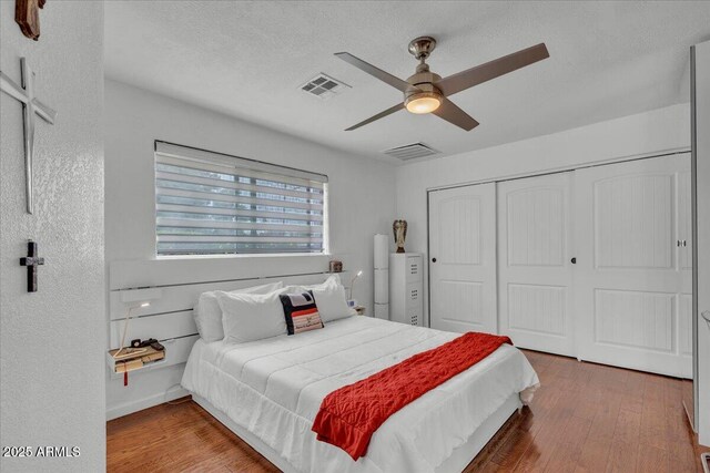 6747 N 12th St, Phoenix, AZ 85014 - bedroom featuring a closet, a textured ceiling, visible vents, ceiling fan, and wood finished floors