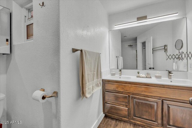 6747 N 12th St, Phoenix, AZ 85014 - bathroom with double vanity, wood finished floors, a shower, and a sink