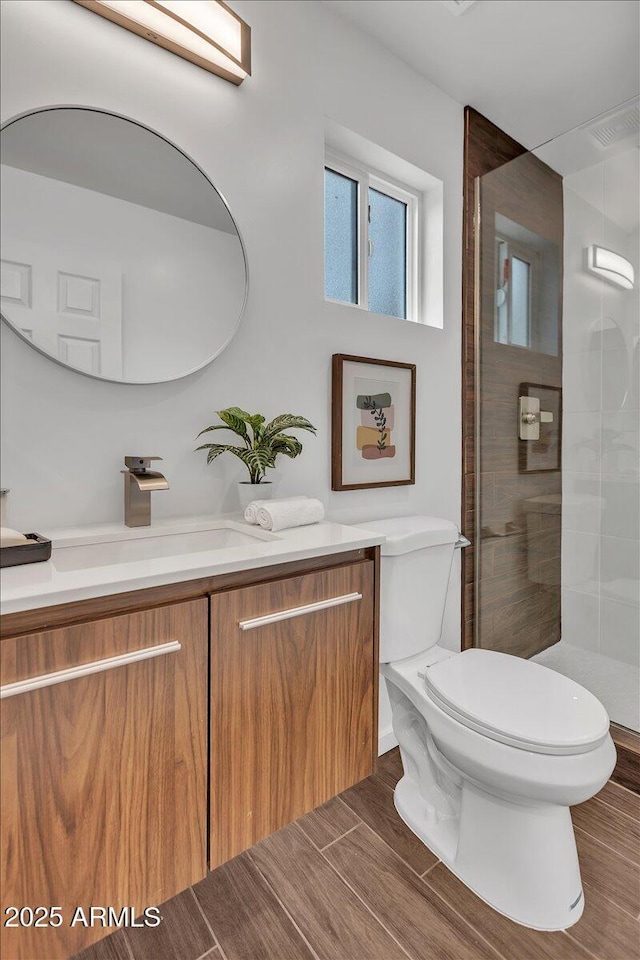 6747 N 12th St, Phoenix, AZ 85014 - full bathroom with wood tiled floor, toilet, a tile shower, and vanity