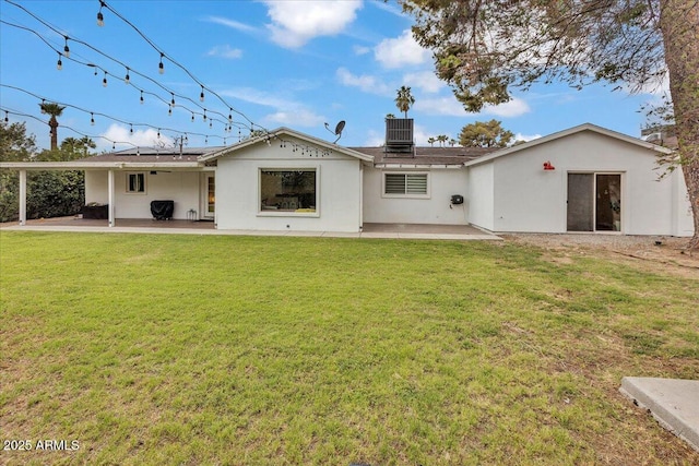6747 N 12th St, Phoenix, AZ 85014 - back of house with a patio area, stucco siding, solar panels, a lawn, and central AC