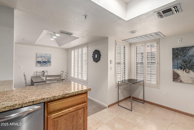 kitchen with baseboards, a textured ceiling, visible vents, and dishwasher