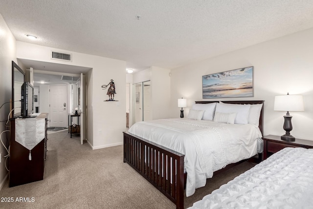 carpeted bedroom with a textured ceiling, a closet, visible vents, and baseboards