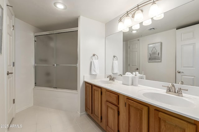 full bath featuring tile patterned floors, visible vents, a sink, and bath / shower combo with glass door