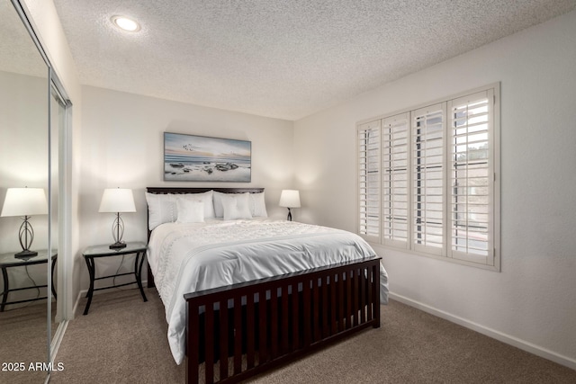 bedroom with carpet, a closet, a textured ceiling, and baseboards