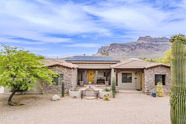 5380 E 14th Ave, Apache Junction, AZ 85119 - view of front of house with stone siding, stucco siding, roof mounted solar panels, and a patio
