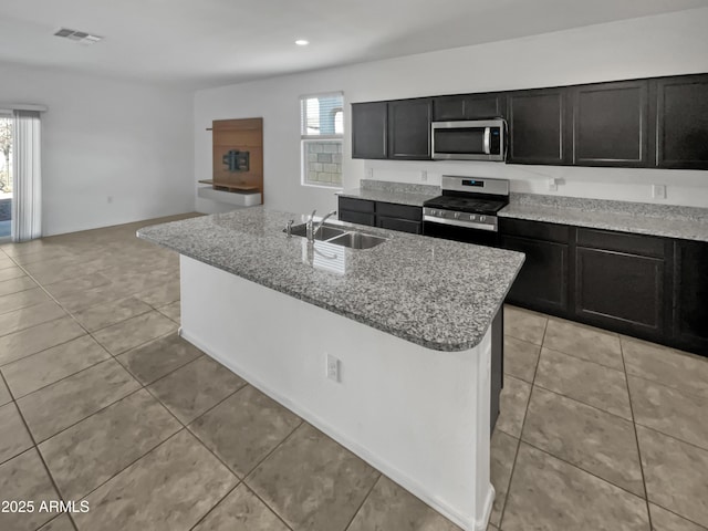 kitchen featuring a healthy amount of sunlight, sink, an island with sink, and stainless steel appliances