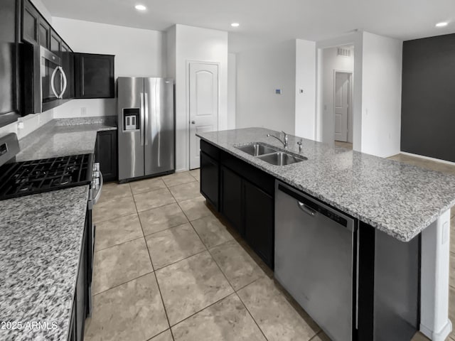 kitchen featuring light stone countertops, sink, stainless steel appliances, a center island with sink, and light tile patterned floors