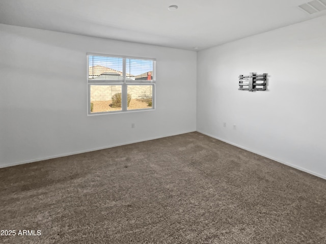 spare room featuring dark colored carpet