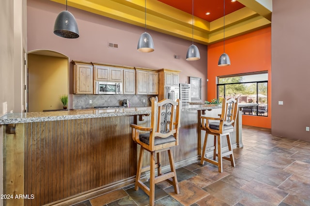 15406 E Cavedale Dr, Scottsdale, AZ 85262 - kitchen with stainless steel microwave, a towering ceiling, backsplash, light stone countertops, and stone tile flooring