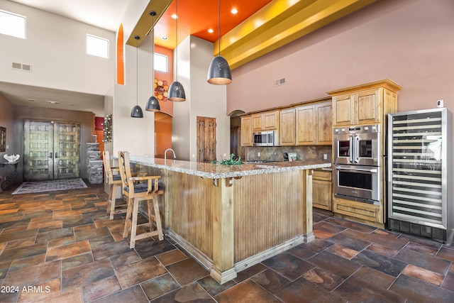 15406 E Cavedale Dr, Scottsdale, AZ 85262 - kitchen featuring wine cooler, stainless steel appliances, a high ceiling, light stone counters, and a peninsula