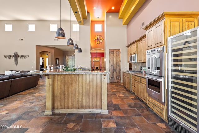 15406 E Cavedale Dr, Scottsdale, AZ 85262 - kitchen with beverage cooler, stainless steel appliances, open floor plan, a towering ceiling, and light stone countertops