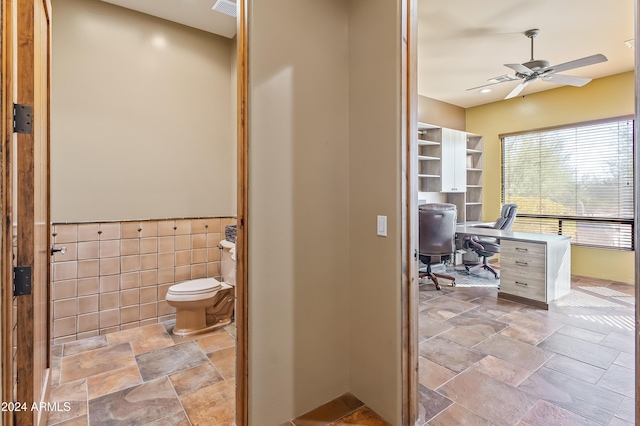 15406 E Cavedale Dr, Scottsdale, AZ 85262 - bathroom with stone tile floors, toilet, ceiling fan, and tile walls
