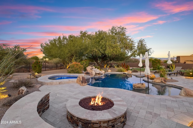 15406 E Cavedale Dr, Scottsdale, AZ 85262 - pool at dusk featuring an outdoor fire pit, a patio area, a fenced backyard, and a pool with connected hot tub
