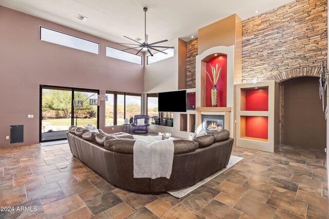 15406 E Cavedale Dr, Scottsdale, AZ 85262 - living room featuring ceiling fan, a glass covered fireplace, a high ceiling, and stone finish floors