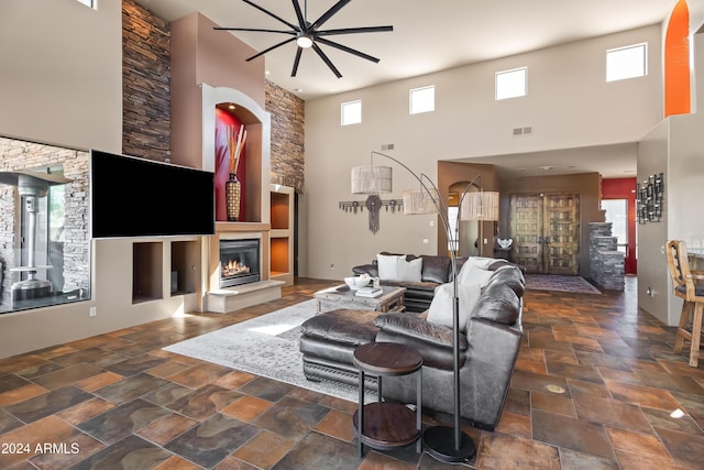 15406 E Cavedale Dr, Scottsdale, AZ 85262 - living area with a high ceiling, ceiling fan, stone finish flooring, a fireplace, and plenty of natural light