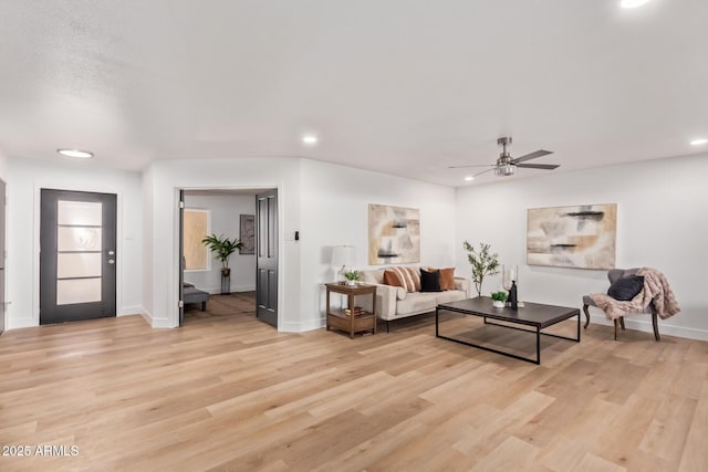 living room featuring a ceiling fan, light wood-type flooring, baseboards, and recessed lighting