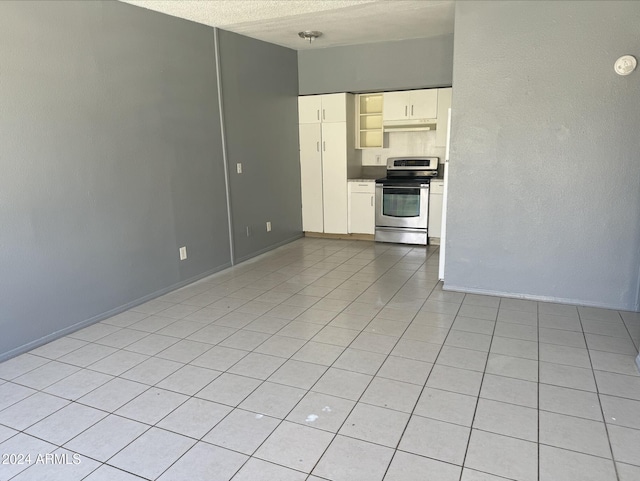 kitchen with light tile patterned flooring, a textured ceiling, and stainless steel range