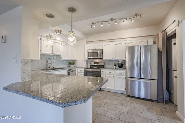 kitchen featuring stainless steel appliances, sink, kitchen peninsula, white cabinetry, and backsplash