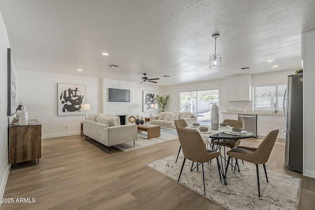 16421 N 34th Ave, Phoenix, AZ 85053 - dining room with light wood-style flooring, ceiling fan, recessed lighting, and a fireplace