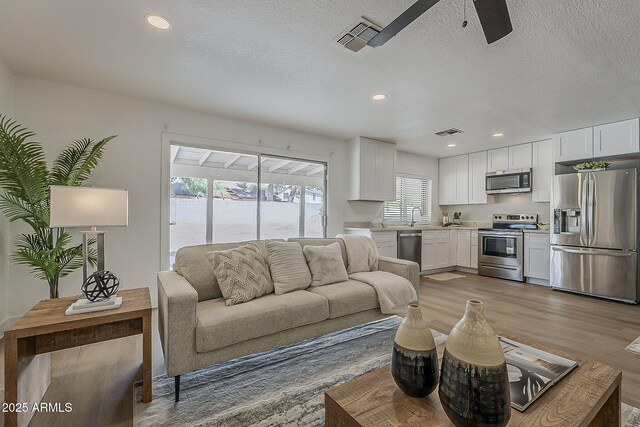 16421 N 34th Ave, Phoenix, AZ 85053 - living area featuring a ceiling fan, light wood-style flooring, recessed lighting, and a textured ceiling
