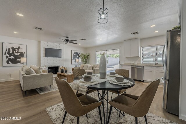 16421 N 34th Ave, Phoenix, AZ 85053 - dining area featuring ceiling fan, a textured ceiling, light wood finished floors, a fireplace, and recessed lighting