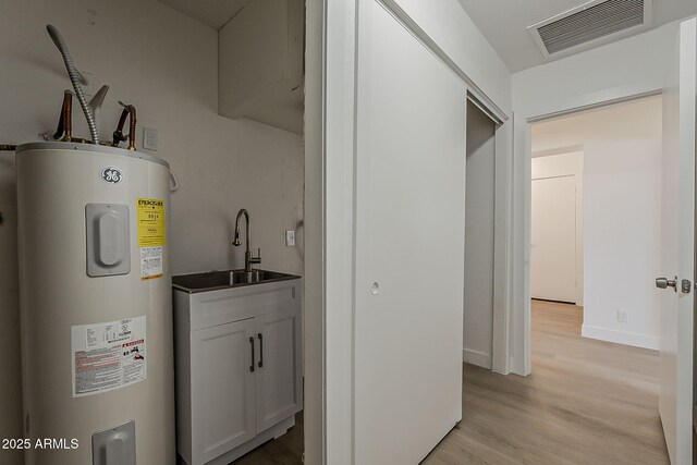 16421 N 34th Ave, Phoenix, AZ 85053 - washroom featuring water heater, cabinet space, and light wood-style floors