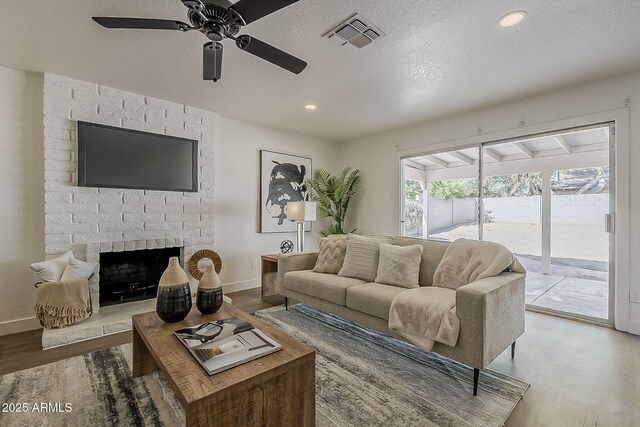 16421 N 34th Ave, Phoenix, AZ 85053 - living area featuring wood finished floors, ceiling fan, a textured ceiling, a fireplace, and recessed lighting