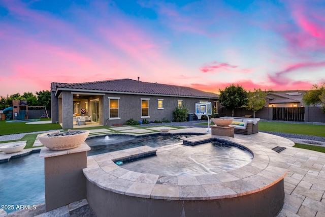 9527 W Whitehorn Way, Peoria, AZ 85383 - patio terrace at dusk with an in-ground hot tub, a patio area, an outdoor living space, and a playground