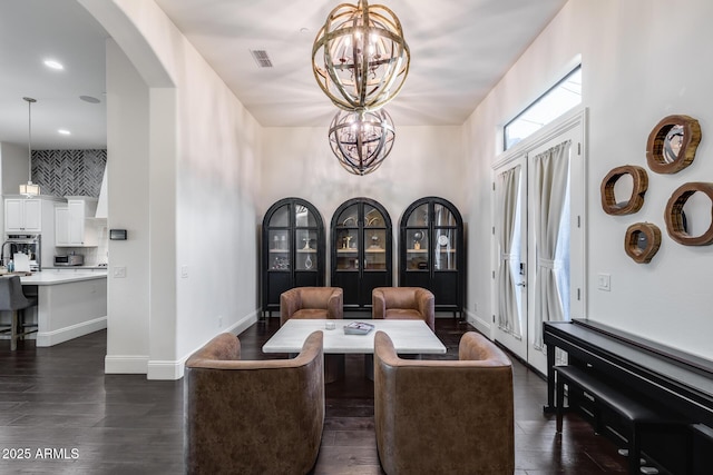 9527 W Whitehorn Way, Peoria, AZ 85383 - dining room with a chandelier, arched walkways, dark wood-style flooring, and baseboards