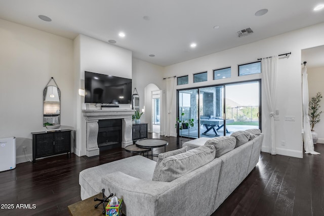 9527 W Whitehorn Way, Peoria, AZ 85383 - living area featuring arched walkways, wood-type flooring, a glass covered fireplace, baseboards, and recessed lighting