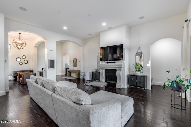 9527 W Whitehorn Way, Peoria, AZ 85383 - living area featuring dark wood-style flooring, baseboards, arched walkways, a fireplace, and recessed lighting