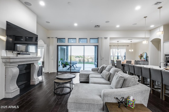 9527 W Whitehorn Way, Peoria, AZ 85383 - living area with arched walkways, dark wood-style floors, a premium fireplace, recessed lighting, and baseboards