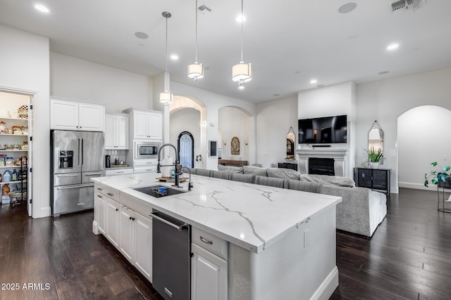 9527 W Whitehorn Way, Peoria, AZ 85383 - kitchen featuring arched walkways, stainless steel appliances, a sink, light stone countertops, and recessed lighting