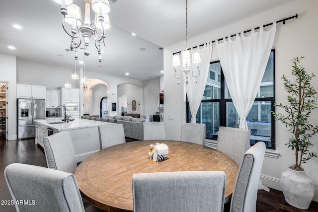 9527 W Whitehorn Way, Peoria, AZ 85383 - dining space featuring a chandelier, arched walkways, dark wood finished floors, and recessed lighting