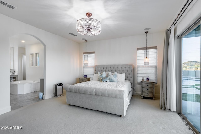 9527 W Whitehorn Way, Peoria, AZ 85383 - bedroom with access to outside, arched walkways, light colored carpet, and ensuite bathroom