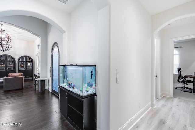 9527 W Whitehorn Way, Peoria, AZ 85383 - corridor featuring wood finished floors, baseboards, a chandelier, and arched walkways