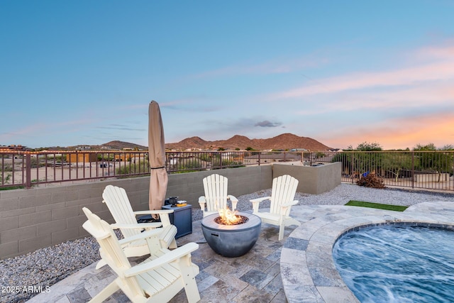 9527 W Whitehorn Way, Peoria, AZ 85383 - patio terrace at dusk with an outdoor fire pit, a mountain view, and a patio