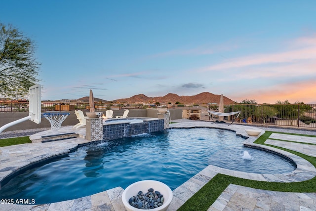 9527 W Whitehorn Way, Peoria, AZ 85383 - pool at dusk featuring a patio area, a pool with connected hot tub, a mountain view, and area for grilling