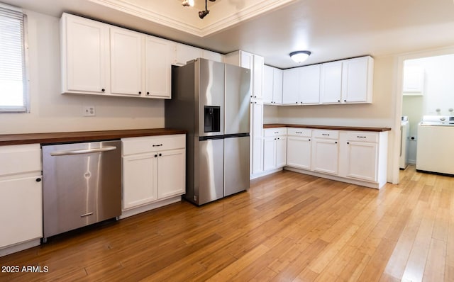 kitchen featuring white cabinetry, light wood-type flooring, appliances with stainless steel finishes, and washing machine and clothes dryer