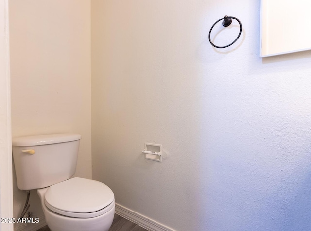 bathroom with baseboards and toilet