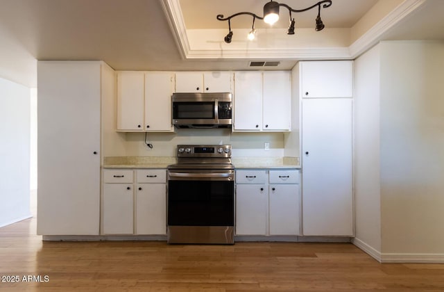 kitchen featuring light countertops, light wood-style flooring, visible vents, and stainless steel appliances