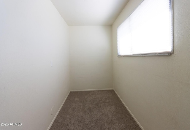 carpeted empty room featuring baseboards