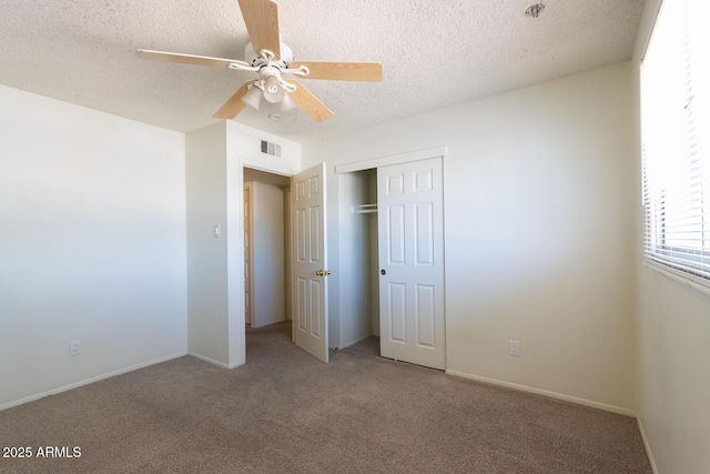 unfurnished bedroom with carpet flooring, visible vents, a closet, and a textured ceiling