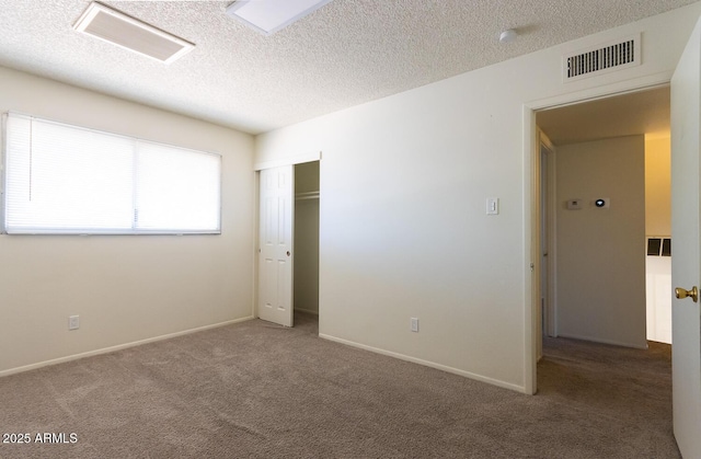 unfurnished bedroom featuring a closet, visible vents, carpet flooring, and a textured ceiling