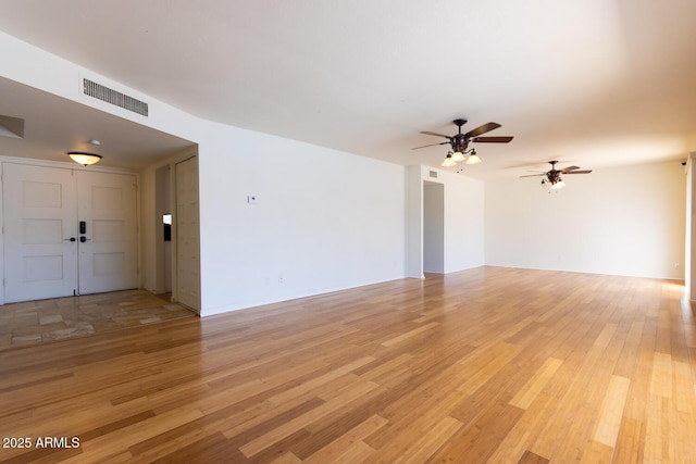 unfurnished living room with light wood-style flooring, visible vents, and ceiling fan