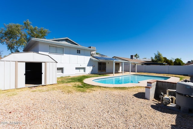 view of swimming pool with an outbuilding, a patio, a fenced backyard, a storage shed, and a fenced in pool